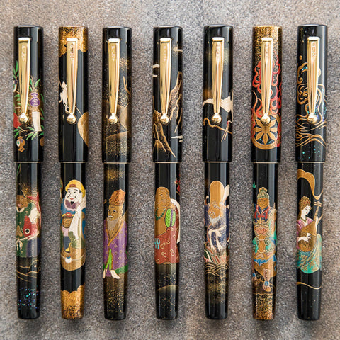 Namiki fountain pens with black lacquer bodies and gold clips each adorned with intricate lacquer artwork