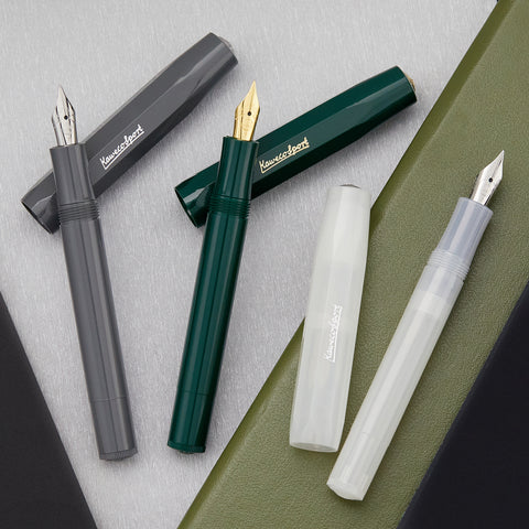 Assorted Kaweco Sport cartridge fountain pens in gray green and white with nibs exposed.