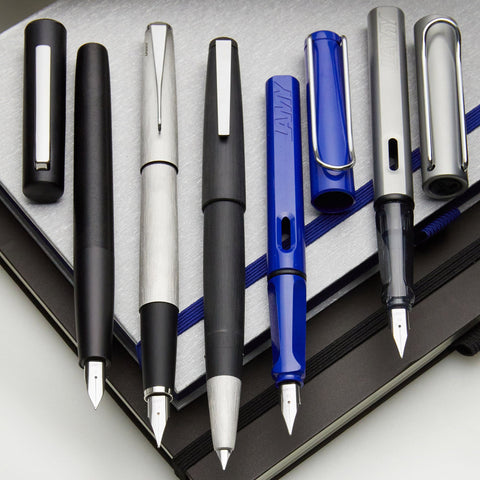 Close up of assorted LAMY pens with metal nibs arranged in a row