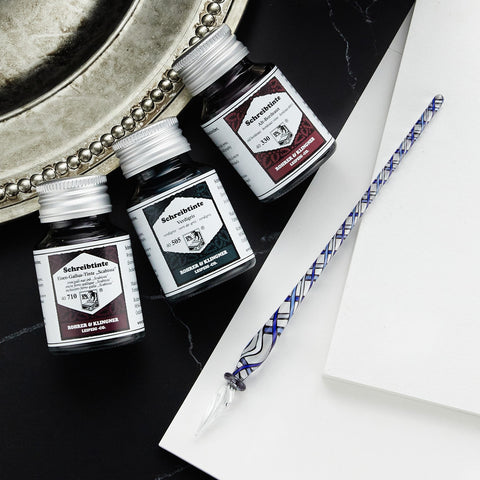 Rohrer & Klingner ink bottles with Schreibtinte labels arranged diagonally on a dark surface