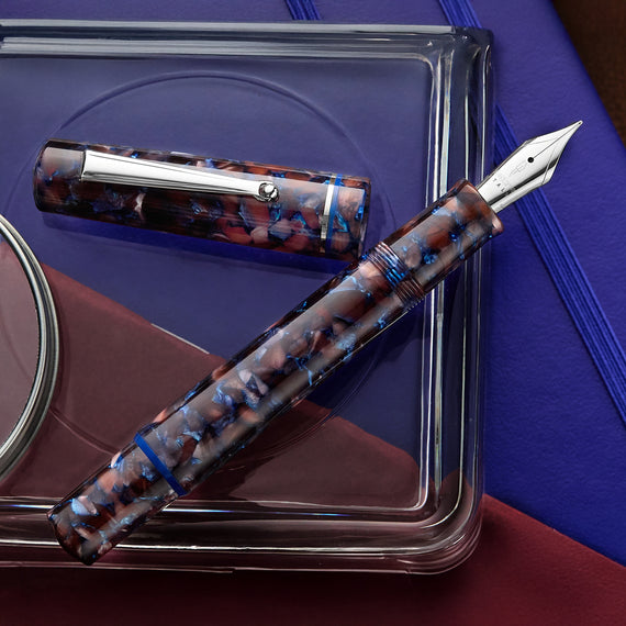 This image features a flecked brown resin body with accents of blue throughout. The pen has silver trim.