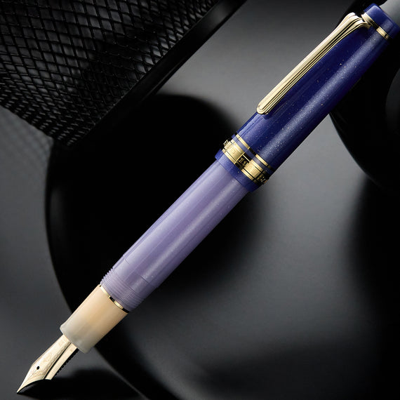Purple fountain pen with gold accents on a dark background