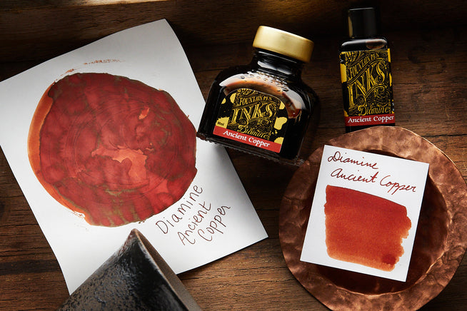 Diamine Ancient Copper Fountain Pen ink swabs and bottles on wooden background