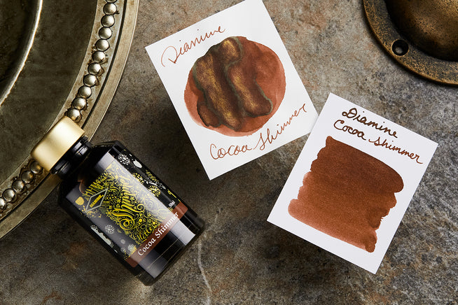 Diamine Cocoa Shimme fountain pen ink bottle with ink splatters