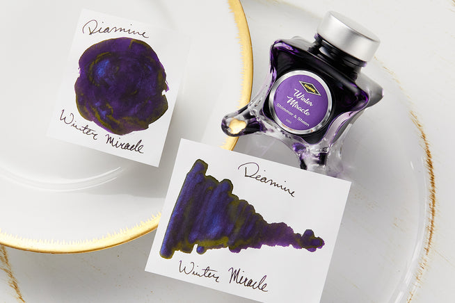 Diamine Winter Miracle ink bottle on white background with ink splatters