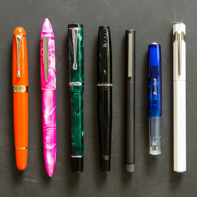 Assorted fountain pens in different shapes on black background