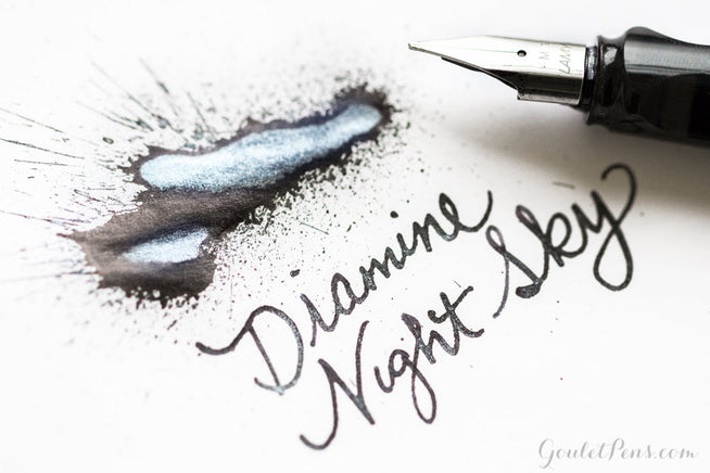 Diamine Night Sky Fountain Pen Ink writing with ink splatter and uncapped LAMY pen