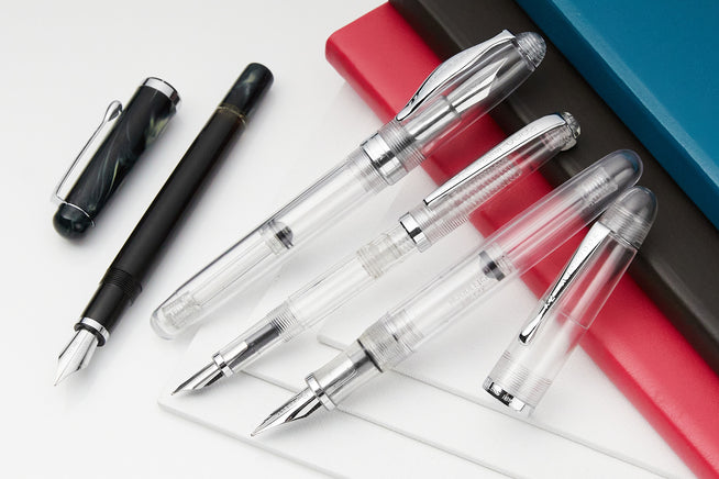 Noodler's Flex pens capped and uncapped against some notebooks