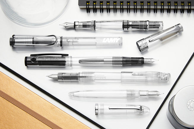 Assorted fountain pens disassembled to show the different filling mechanisms