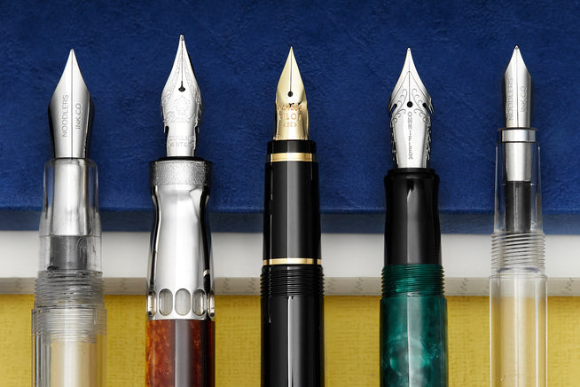 Close up of multiple fountain pen nibs with different grinds on them