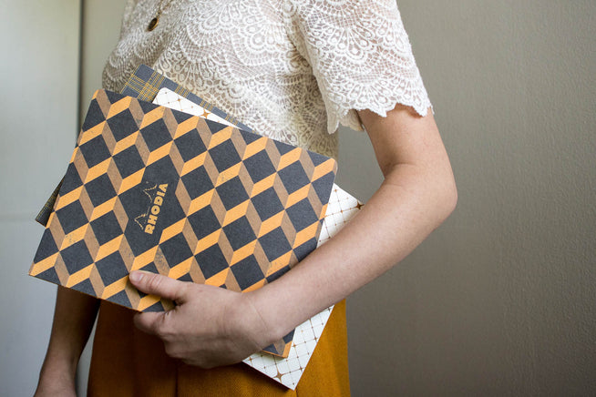 Notebooks held under an arm