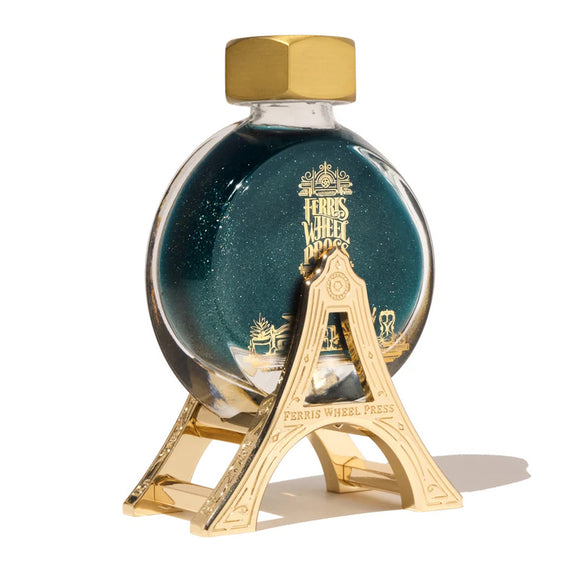 Ferris Wheel Press bottle with gold cap and stand on a white background