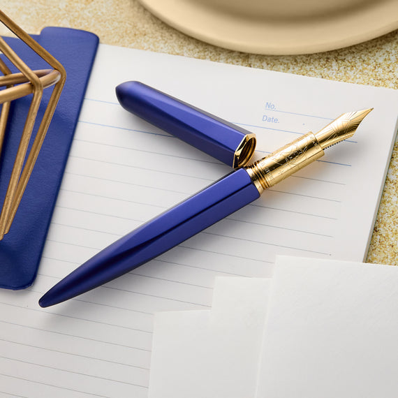 Blue and gold pen on a notebook with a blurred background