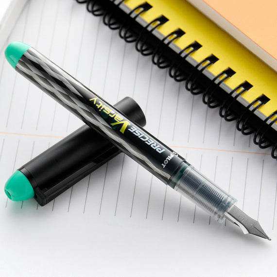 Fountain pen with green cap on a notebook page