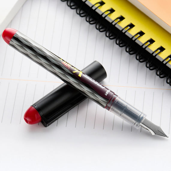 Fountain pen with red cap on a lined notebook page