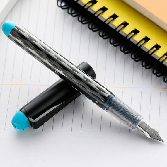 Fountain pen with blue cap on a lined notebook page
