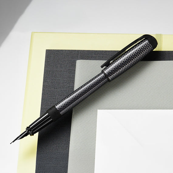 Fountain pen with decorative cap on a checkered surface