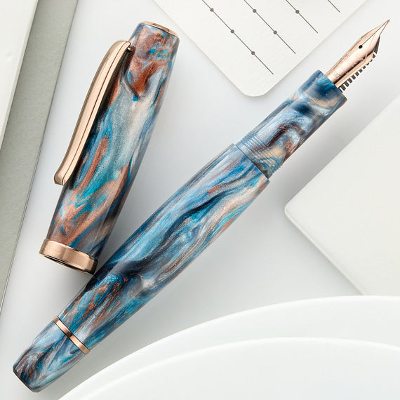 Fountain pen with blue and brown marbled design on a light background