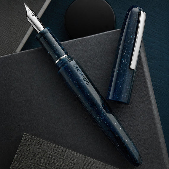 Blue fountain pen with cap on a dark surface