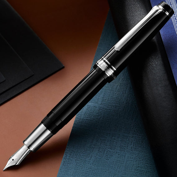 Black fountain pen with silver accents on a textured surface