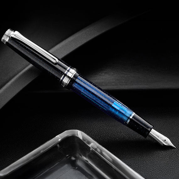 Fountain pen with blue accents on a dark surface