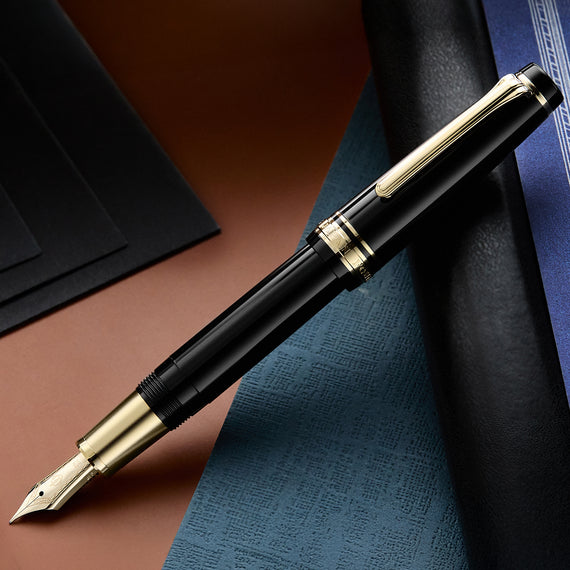 Fountain pen with black and gold accents on a textured surface