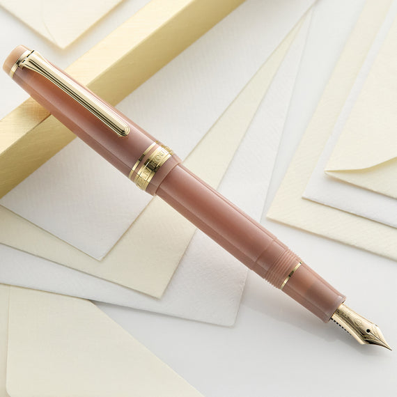 Pink fountain pen with gold accents on a white background
