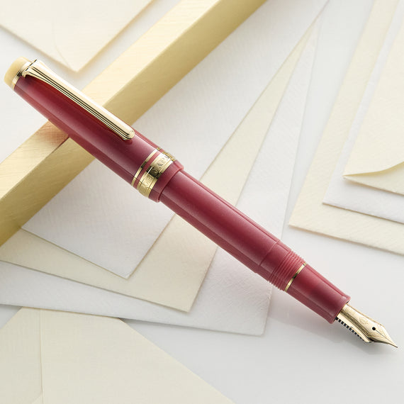 Maroon fountain pen with gold accents on a white background