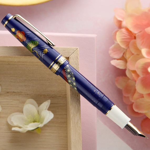Decorative fountain pen with floral design on a pink background