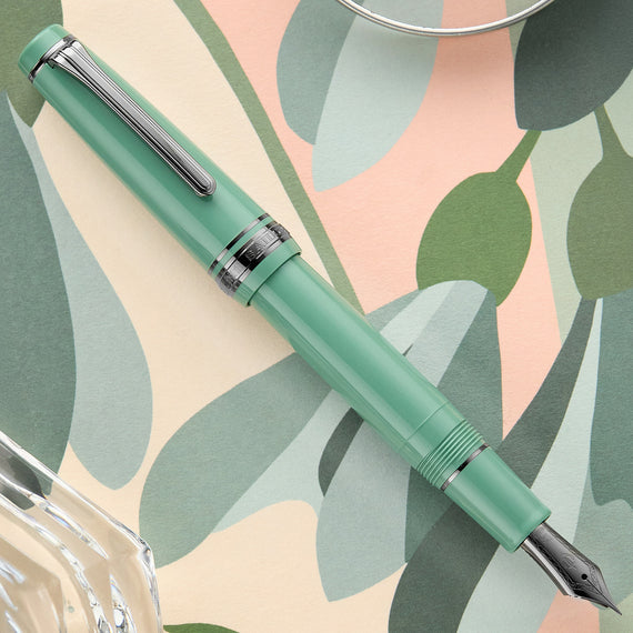 Green fountain pen on a leaf-patterned background