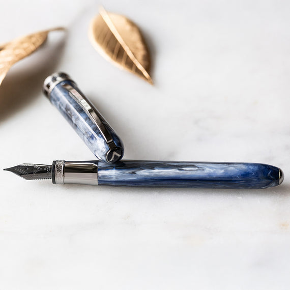 Fountain pen with blue and silver design on a white surface